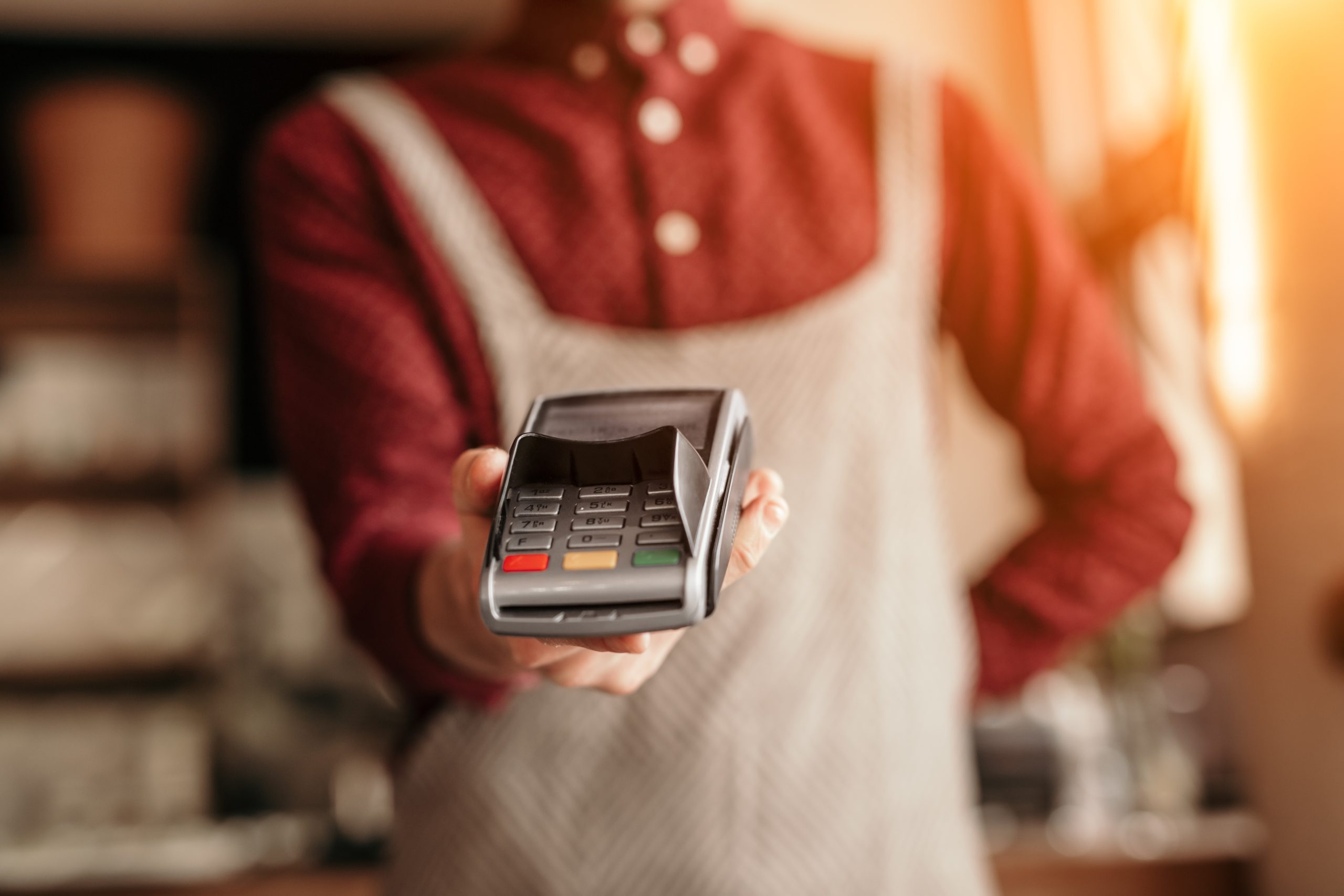 camarero sosteniendo una máquina POS para pago en un restaurante