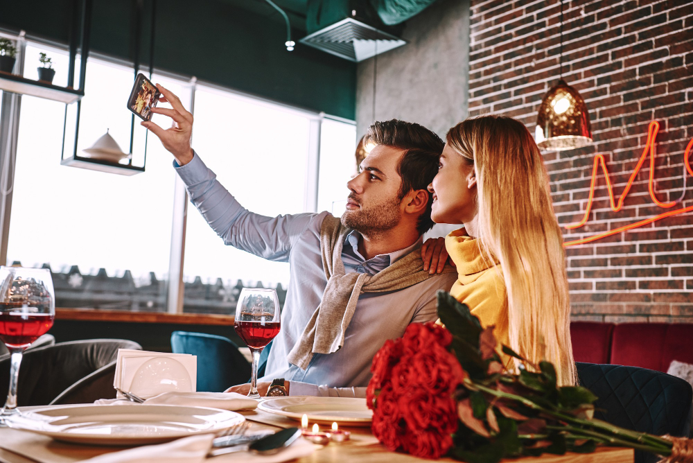 Casal tirando selfie para o Instagram em restaurante no dia dos namorados
