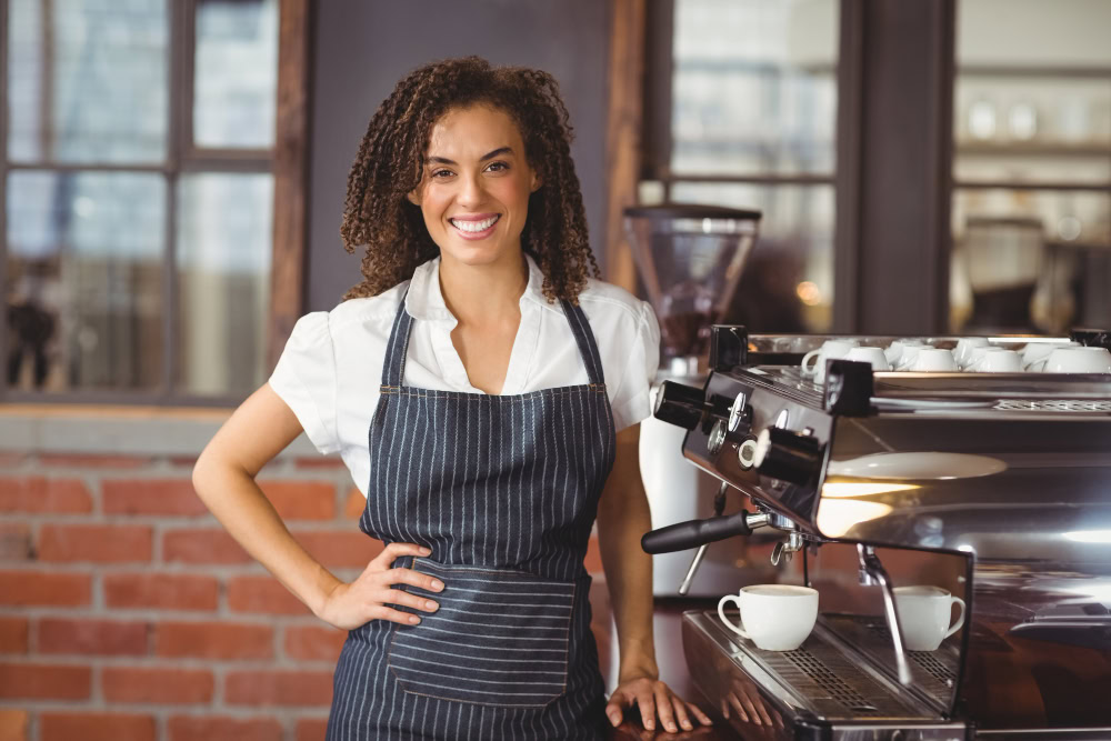 barista ao lado de uma máquina de espresso em cafeteria