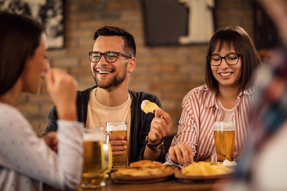 amigos comendo porção de petiscos em bar