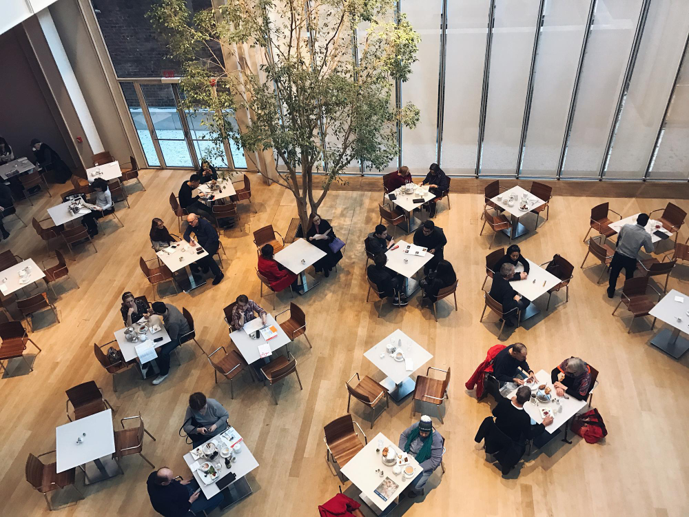 visão de cima do salão de um restaurante, com mesas ocupadas e desocupadas por clientes, em referência ao revpash
