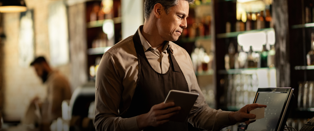 waiter placing an order on a POS, illustrating commercial automation in bars and restaurants